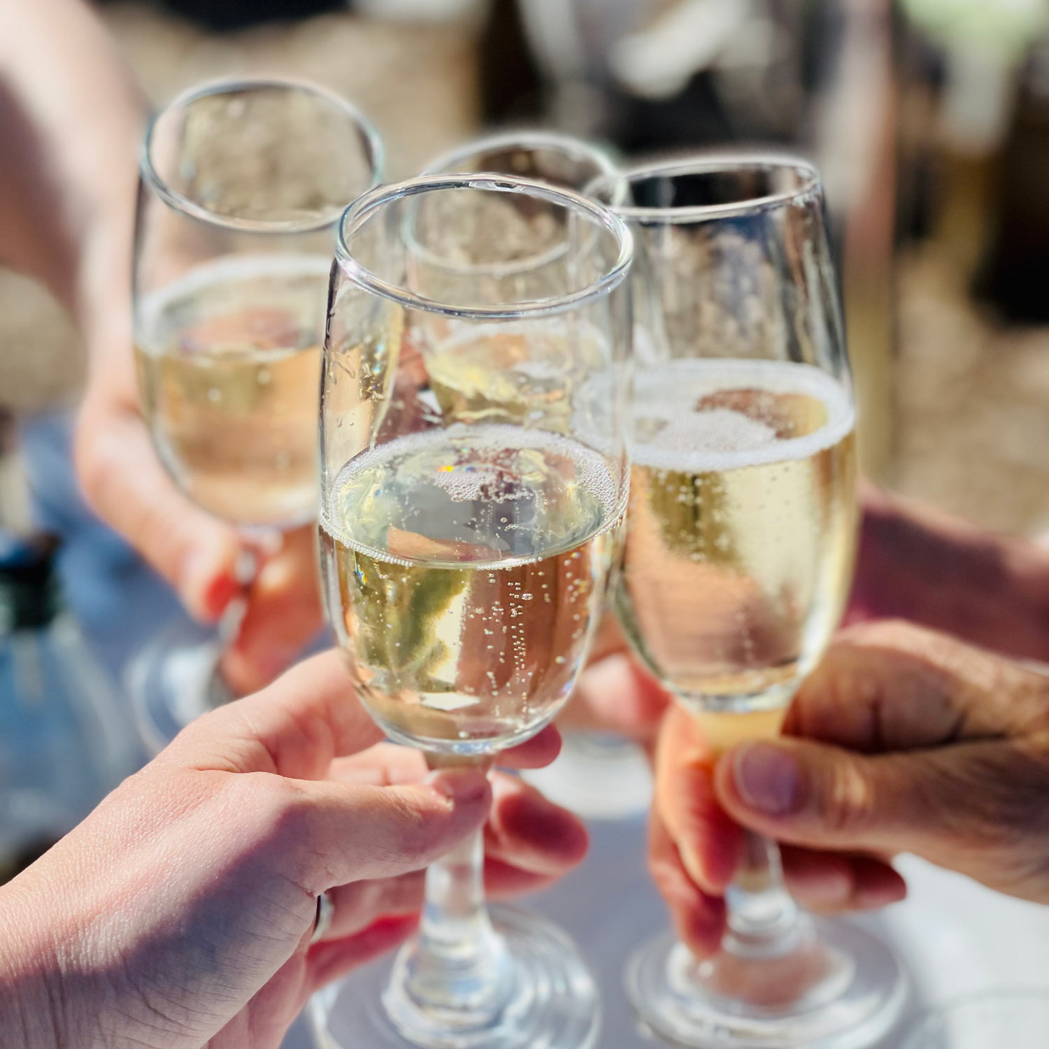 Vier champagne glazen vastgehouden met in de glazen bubbels