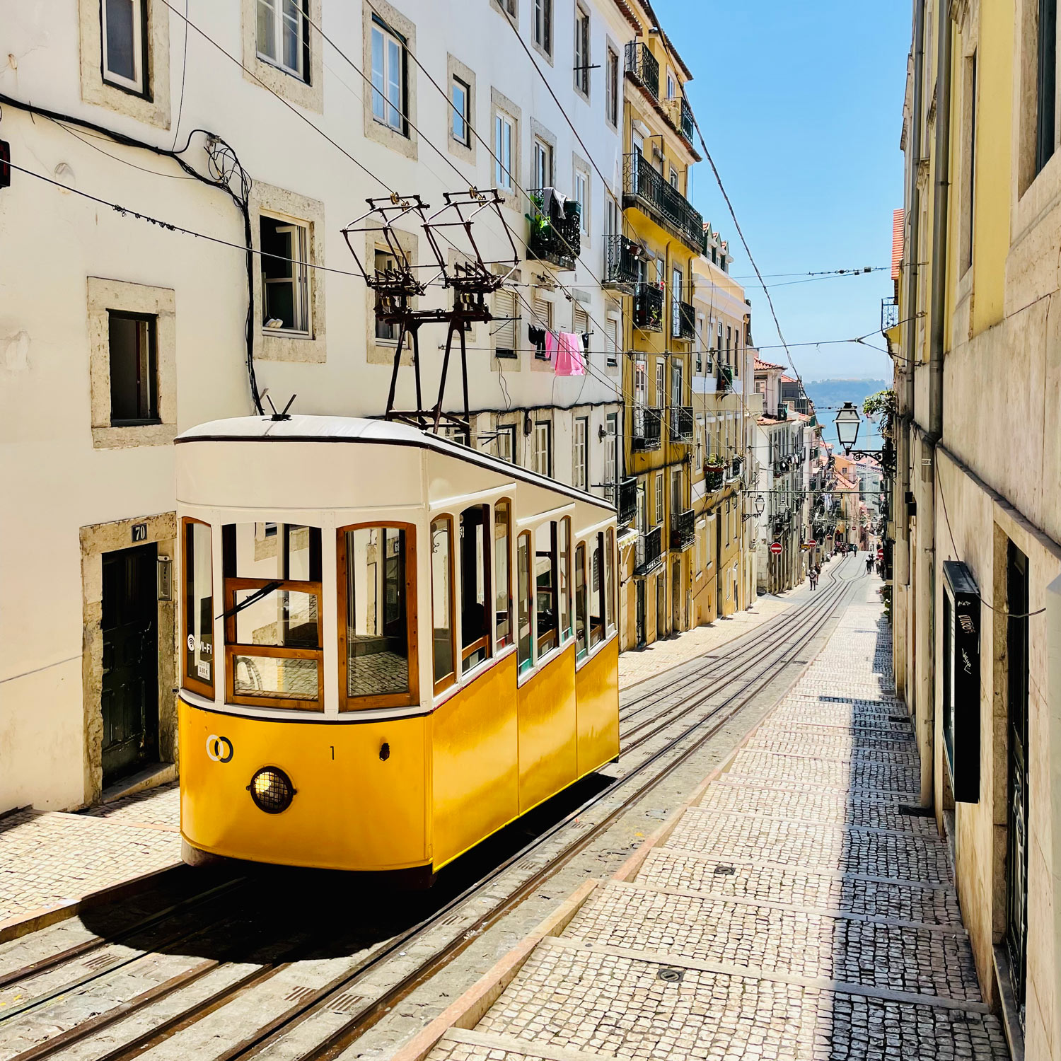 Een gele kabeltram op een stijle heuvel in de stad Lissabon